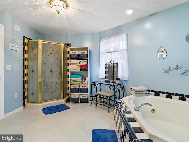 bathroom featuring a textured ceiling, a jetted tub, tile patterned floors, and a shower stall