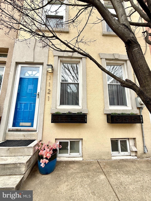 doorway to property featuring stucco siding