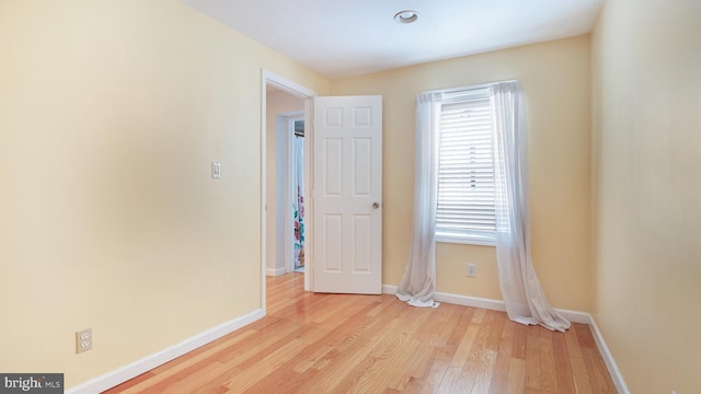 empty room with light wood-type flooring and baseboards