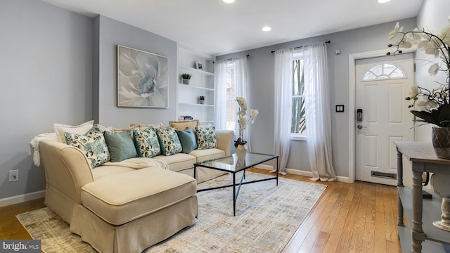 living area featuring light wood-type flooring, baseboards, and recessed lighting