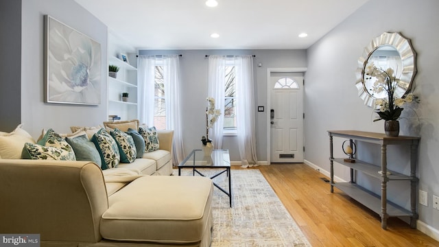 living area featuring light wood-style floors, baseboards, and recessed lighting