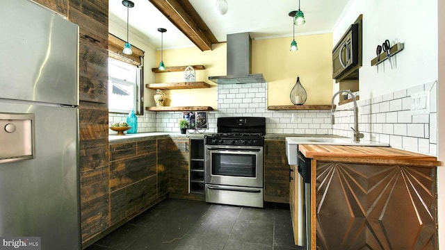 kitchen featuring island range hood, a sink, ornamental molding, appliances with stainless steel finishes, and beamed ceiling