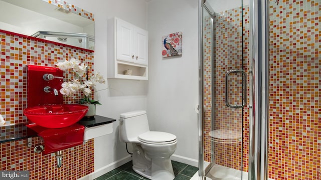 full bath featuring a stall shower, a sink, toilet, and tile patterned floors