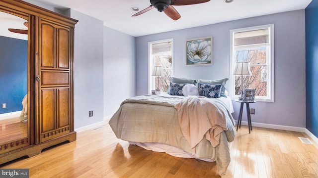 bedroom with visible vents, light wood-style flooring, and baseboards