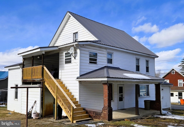 view of front of home with metal roof, a porch, and stairway