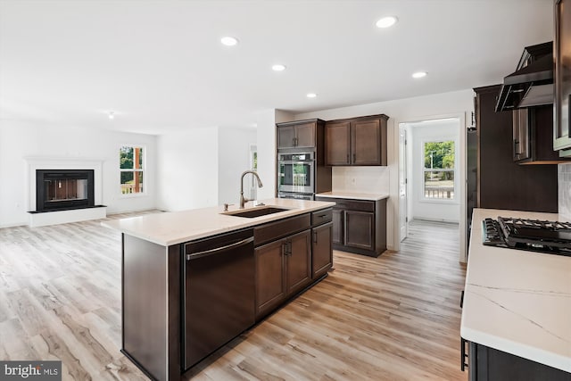 kitchen with dishwashing machine, light wood-style flooring, a sink, black gas cooktop, and stainless steel oven
