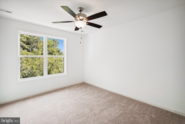 spare room with visible vents, baseboards, ceiling fan, and carpet flooring
