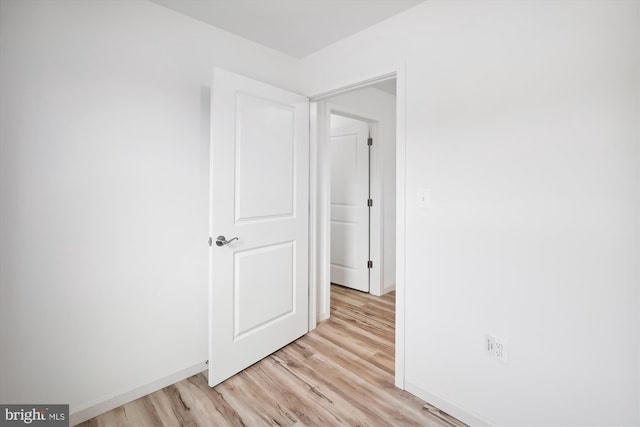 unfurnished bedroom with light wood-type flooring and baseboards