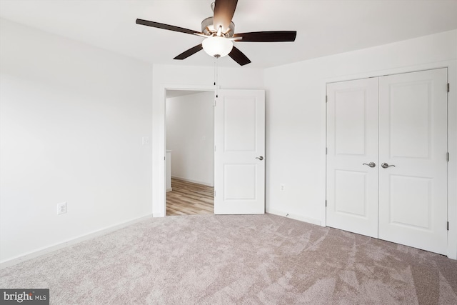 unfurnished bedroom with a closet, carpet floors, baseboards, and ceiling fan