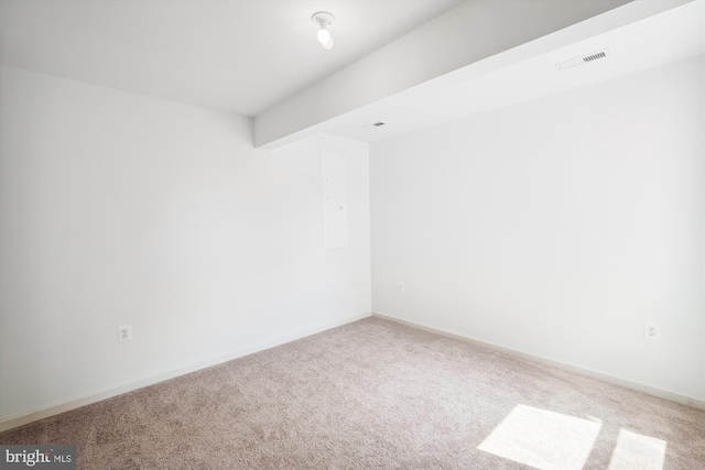 carpeted spare room with beam ceiling, baseboards, and visible vents