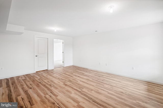 empty room with baseboards and light wood-type flooring