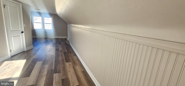 hall with baseboards, lofted ceiling, and dark wood-style flooring