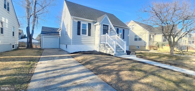 bungalow featuring an outbuilding, fence, roof with shingles, a front yard, and a garage