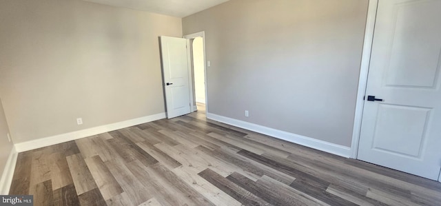 unfurnished bedroom featuring wood finished floors and baseboards