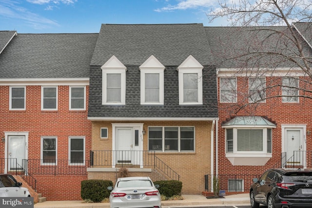 townhome / multi-family property with brick siding and roof with shingles