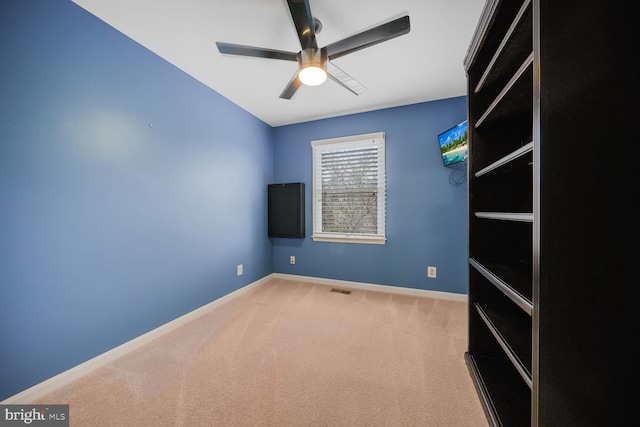 unfurnished room with baseboards, carpet floors, visible vents, and ceiling fan