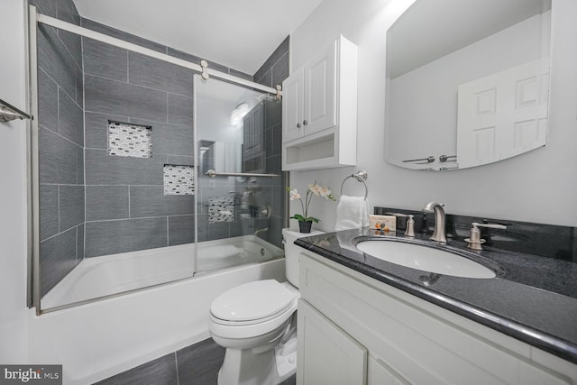 full bathroom featuring combined bath / shower with glass door, toilet, and vanity