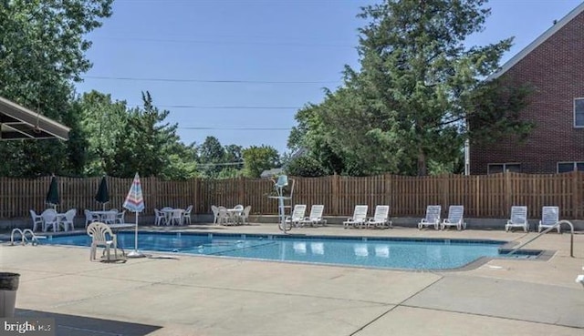 community pool featuring a patio and fence