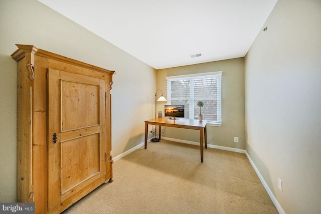 office area featuring light carpet, visible vents, and baseboards