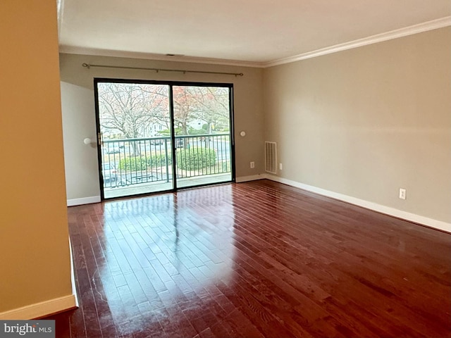 unfurnished room with baseboards, dark wood-style floors, visible vents, and ornamental molding