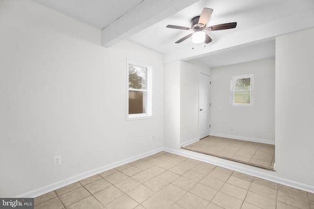 unfurnished room featuring light tile patterned floors, a ceiling fan, and baseboards