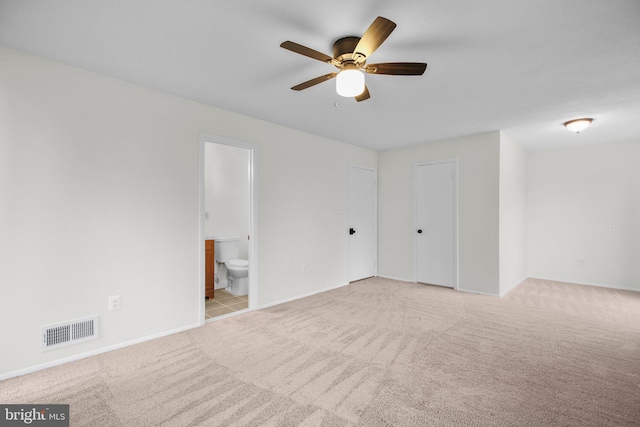 empty room with baseboards, carpet flooring, visible vents, and a ceiling fan