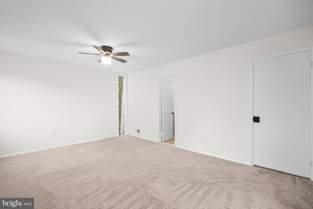 carpeted spare room with ceiling fan