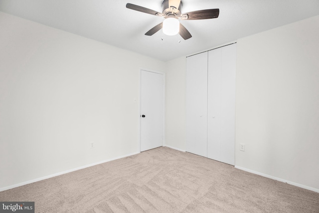 unfurnished room featuring carpet, baseboards, and a ceiling fan