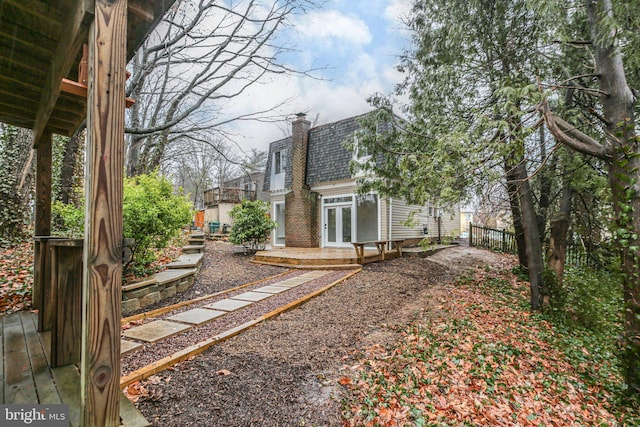 view of yard featuring french doors, fence, and a deck