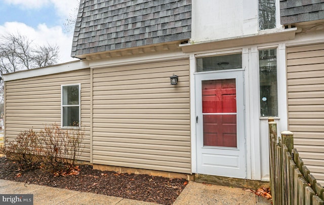 property entrance with roof with shingles and mansard roof