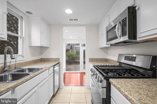 kitchen featuring stainless steel appliances, a sink, visible vents, and white cabinetry