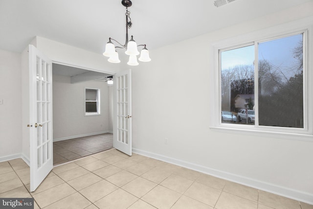 unfurnished dining area with french doors, visible vents, an inviting chandelier, light tile patterned flooring, and baseboards