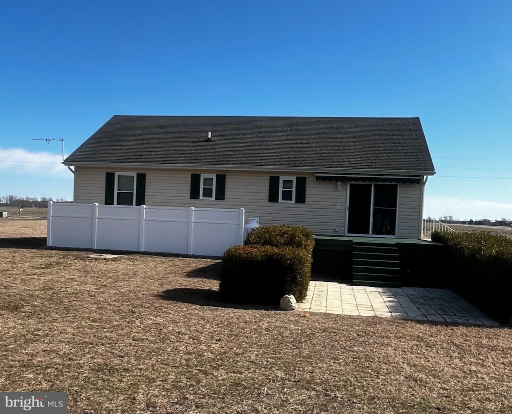 rear view of property featuring a patio area and fence