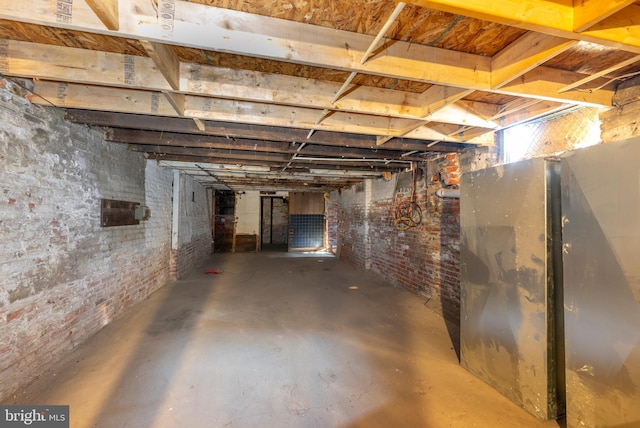 unfinished basement featuring brick wall