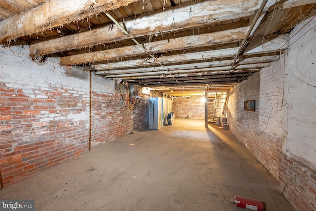 unfinished basement featuring brick wall