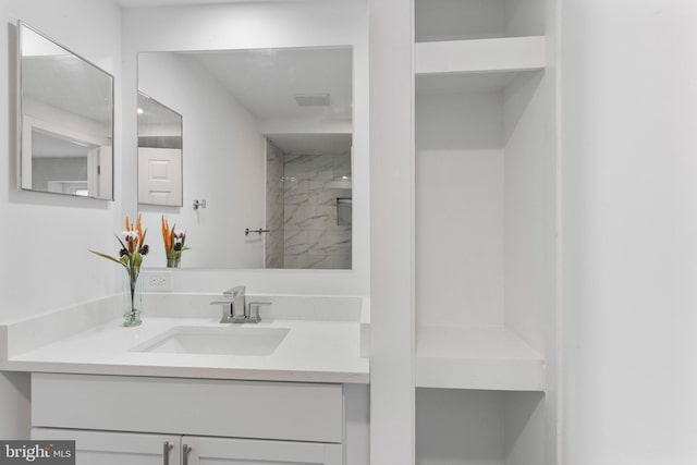 bathroom featuring a shower and vanity