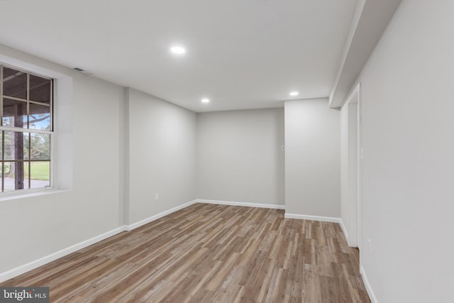 below grade area with light wood-style floors, recessed lighting, visible vents, and baseboards