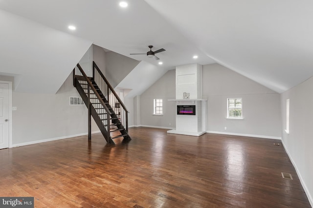 unfurnished living room with visible vents, stairway, vaulted ceiling, wood finished floors, and baseboards