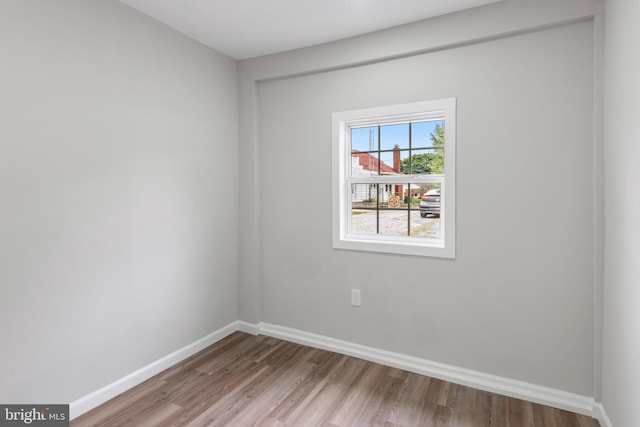 empty room with light wood-type flooring and baseboards