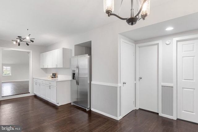 kitchen featuring white cabinets, dark wood-style flooring, light countertops, stainless steel refrigerator with ice dispenser, and a notable chandelier