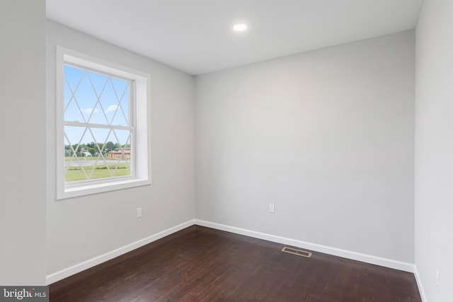 empty room featuring baseboards, visible vents, dark wood-style flooring, and recessed lighting