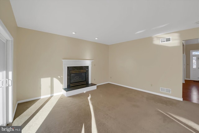 unfurnished living room with a fireplace, visible vents, and baseboards