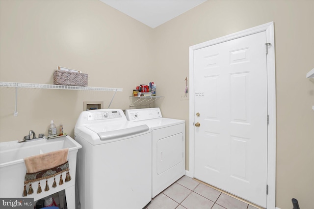 laundry area with light tile patterned floors, laundry area, a sink, and washing machine and dryer