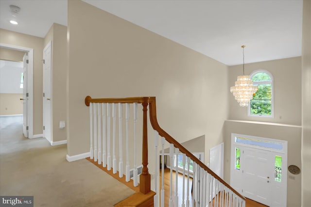 entrance foyer with a chandelier, stairs, and baseboards