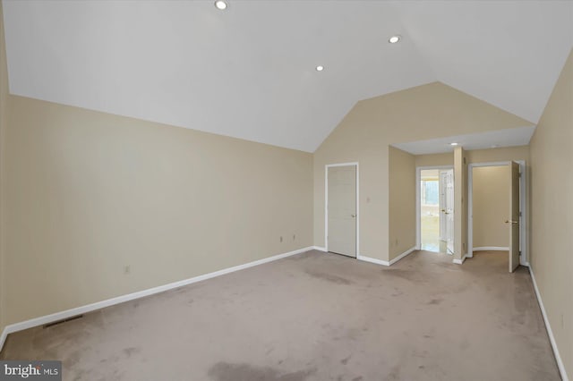 interior space featuring lofted ceiling, recessed lighting, carpet floors, visible vents, and baseboards