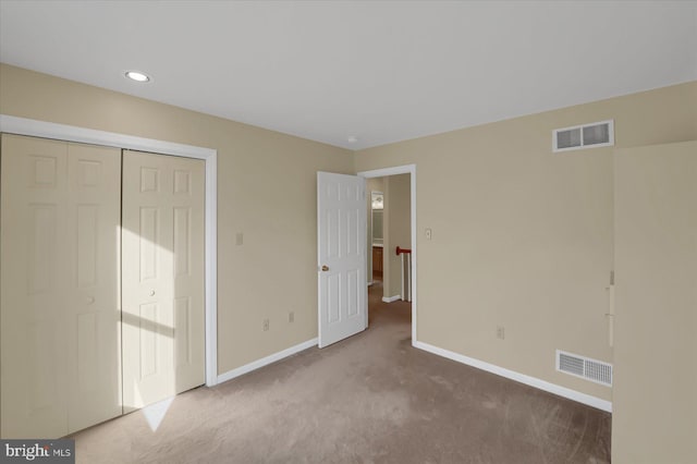 unfurnished bedroom featuring a closet, carpet, visible vents, and baseboards