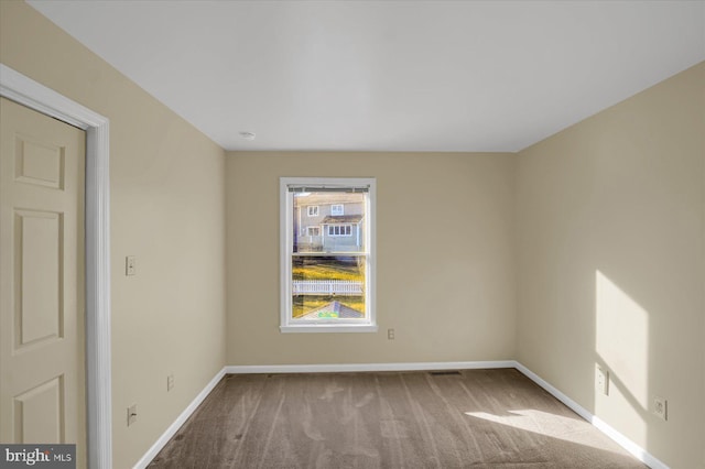 spare room with carpet flooring and baseboards