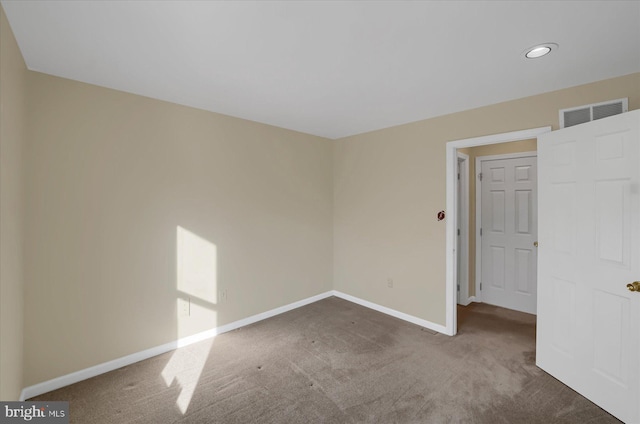 carpeted empty room featuring visible vents and baseboards