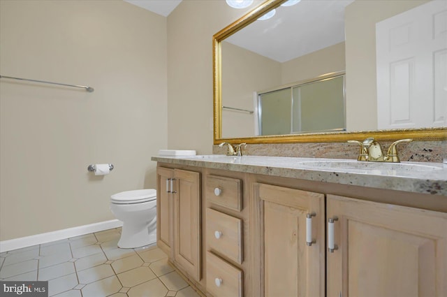 full bath with double vanity, a stall shower, a sink, and toilet