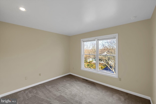 unfurnished room with carpet floors, visible vents, baseboards, and recessed lighting